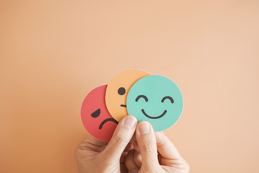 image of hand holding round face emotion cards expressing feelings 